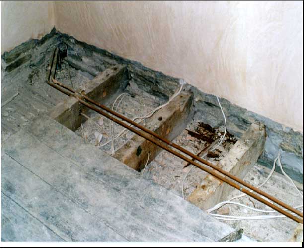 Joists rotted in a wall, with a llath and plaster ceiling beneath